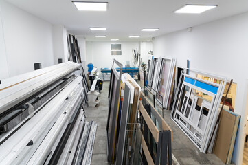 Aluminum and pvc window frames stockpiled in a carpenter's workshop