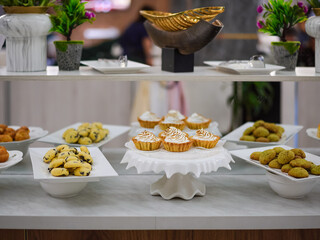 Buffet in Hotel. Dessert and Fruits section including lemon meringue tart, cookies and biscuits and fresh bananas. Selective focus on the meringue tart.