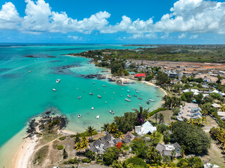 Colorful buildings and boats along a vivid blue bay in Grand Baie, Mauritius