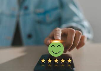 Businessman uses smartphone to provide five-star feedback for customer satisfaction survey,...