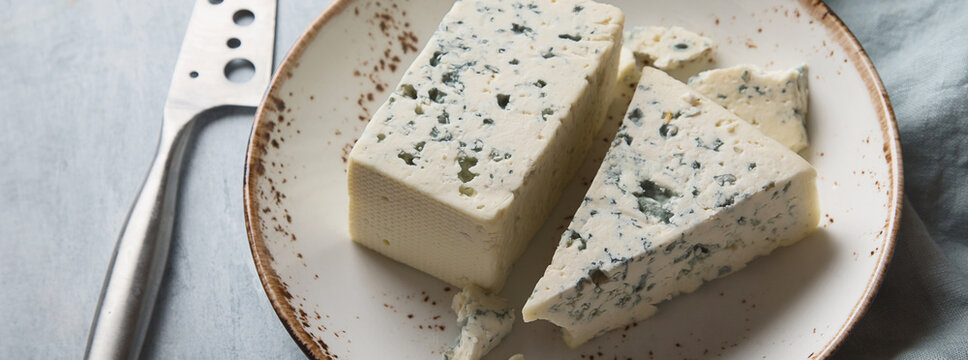 Blue cheese in a plate with knife.