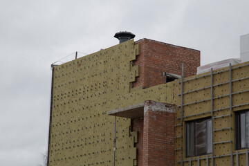 Installing thermal insulation on the wall of a new building