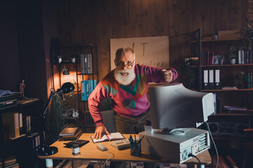 Elderly computer programmer working in a cozy home office environment, wearing a stylish colorful...