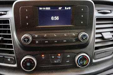 Center com controls of radio, LCD screen, and climate control inside a vehicle.