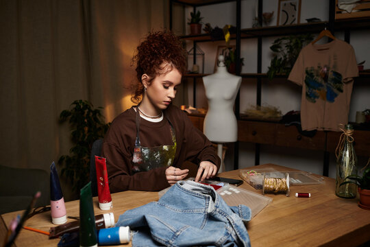 Creative young woman showcases her DIY skills in a modern crafting space full of vibrant materials