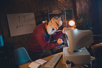 Elderly professional working on old computer indoors showcasing nostalgia and focus on IT...