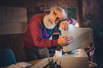 Elderly man enjoying technology while working from home, showcasing senior IT specialist engrossed...