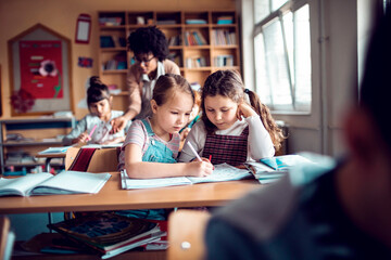 Elementary school girls working together on assignment in classroom