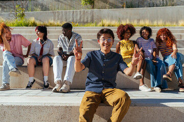 Fototapeta premium Multiethnic group of young friends meeting and having fun outdoors - Multiracial happy and stylish teen students bonding in the city, concepts about youth, teenagers lifestyle and diversity