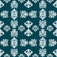 A decorative pattern featuring intricate floral and scroll designs in white on a deep teal background, ideal for textiles or wallpaper.