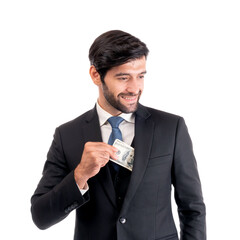 Confident businessman in elegant suit putting dollar banknote into pocket, symbolizing financial...