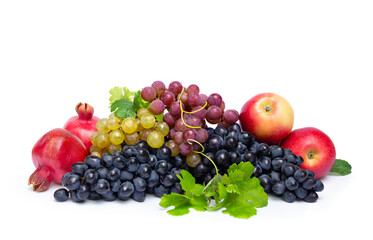 Fresh sweet ripe blue, pink, yellow grapes with green leaves, red apples, garnets on a white...