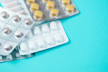 Various pills and medicines arranged on a blue background with space for text