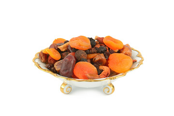 A selection of dried fruits in a vintage porcelain fruit bowl isolated on white.