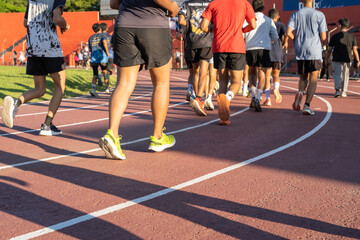 Fototapeta premium A group of participants jogs on a track during morning hours, teamwork, and exercise. The image conveys an active lifestyle and collective motivation, perfect for sports and health themes.