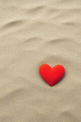 Fototapeta premium A red heart stands out against a textured gray background, symbolizing love and connection.