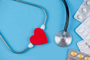 stethoscope and pills on blue background, heart health care and medical technology concept, selective focus, copy space for design