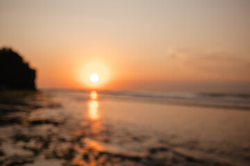 Obraz premium View of the orange sunset over the ocean is out of focus. Beautiful blurred background of nature and evening sky