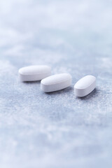 Amino acids tablets on wooden background. Soft focus. Close up