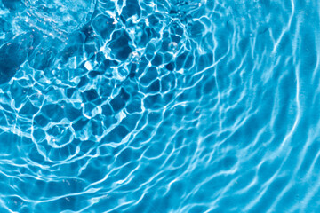 turquoise water surface with ripples and to circles in diagonal direction, wave clean transparent water in blue, abstract background