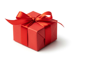 Obraz premium A single red gift box, wrapped and tied with a silk ribbon, sits on a white background.