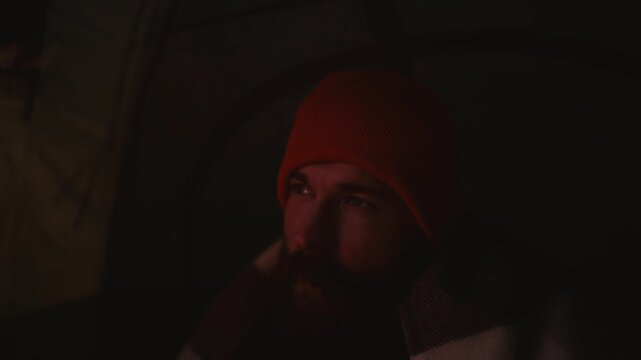 Cozy Camping Moment in Iceland: Man Enjoys Hot Tea Inside Tent