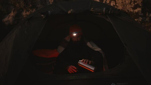 Cozy Camping Moment in Iceland: Man Enjoys Hot Tea Inside Tent