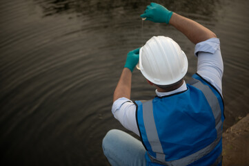 Environmentalists collect water samples from a dam in test tubes