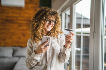 Fototapeta premium woman use mobile phone and credit card for online purchase at home