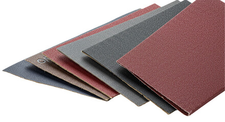 A close up shot showing an assortment of sandpaper sheets in varying colors and grit levels neatly stacked
