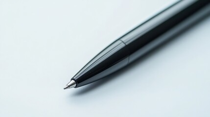 A black ballpoint pen lying diagonally on a white background.