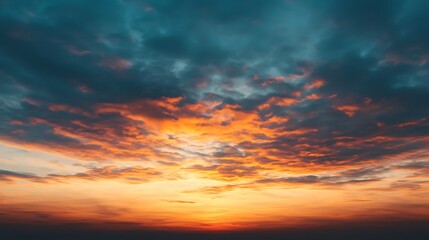 Fototapeta premium Vibrant Colorful Sky at Sunset: Fiery Orange Hues Blend with Deep Blues and Grays in a Cloudscape.