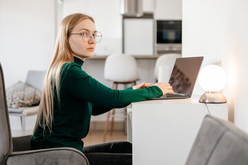 Young woman concentrating while working remotely on her laptop at home
