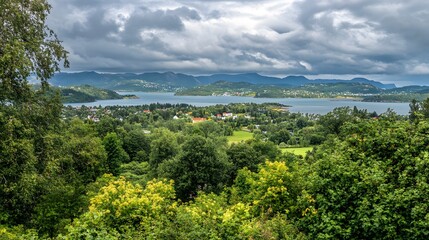 Obraz premium Scenic Coastal Village Landscape with Lush Green Foliage and Dramatic Sky