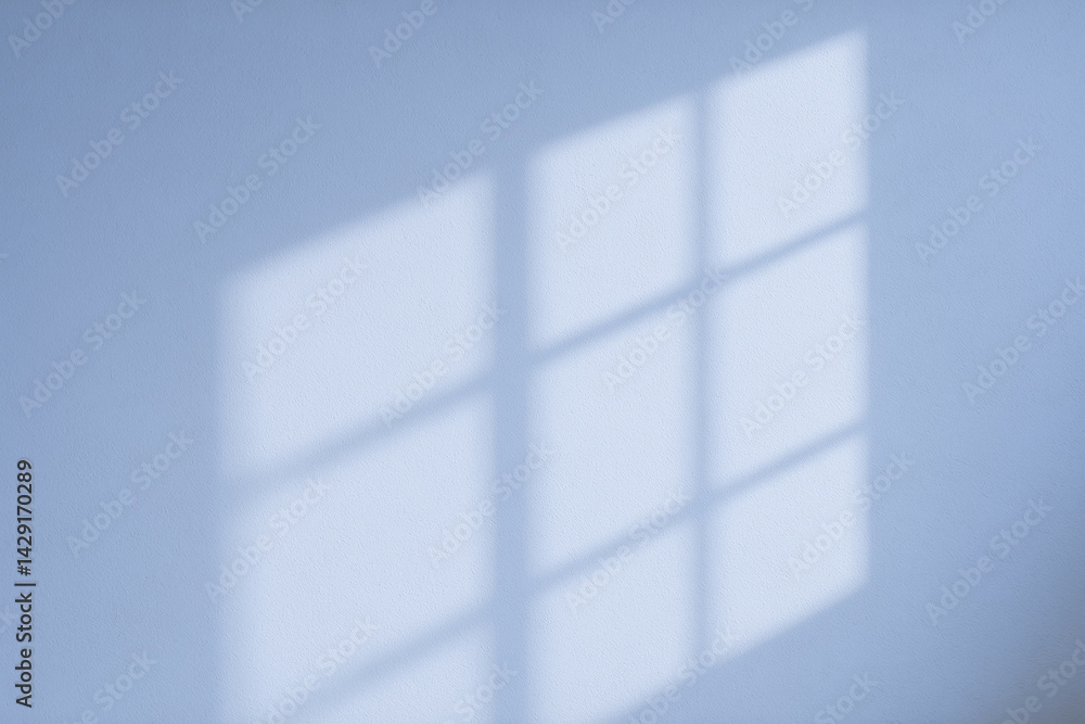 Poster a warm, minimalistic shadow of a window pattern cast on a light-colored wall, creating a serene atmo