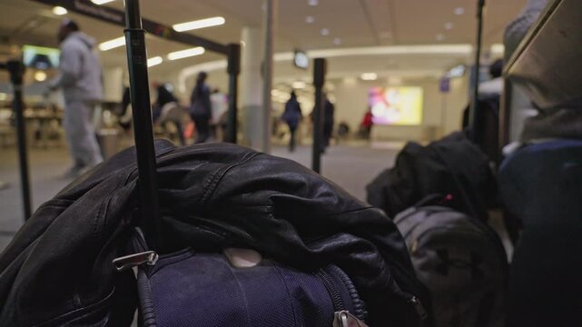 Unattended luggage and jacket at busy airport terminal while waiting for flight