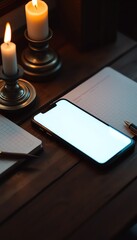 Smartphone with Blank Screen on Wooden Desk beside Notebooks and Lit Candles Perfect for Mockups and Relaxation Scenes