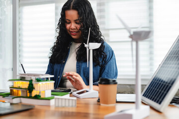 Female architect analyzes energy efficiency by calculating solar panel output, wind turbine...