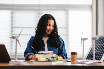 Young architects or design students are studying house models and the use of renewable energy in an Eco House design project with house models.