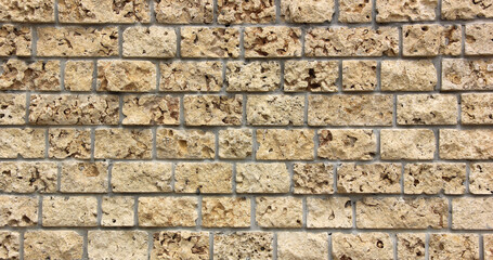 Modern beige limestone cladding forming a textured wall background