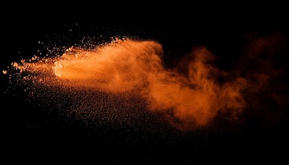 freeze motion of orange color powder exploding on black background