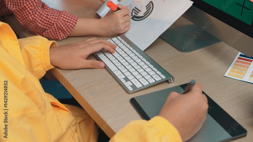 Aufkleber two individuals focus on a creative project using a graphic tablet and keyboard at a modern desk, sh