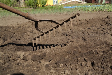 rake against the background of soil, robot in the garden