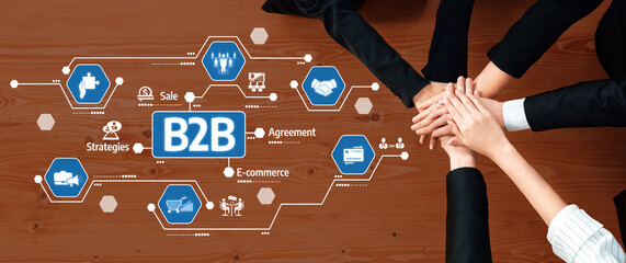This image illustrates a collaborative business partnership in B2B settings, featuring diverse hands joining over digital icons symbolizing agreements and strategy in modern commerce. Amity
