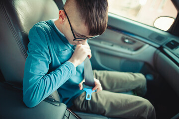 Child buckling seatbelt in car interior for safety