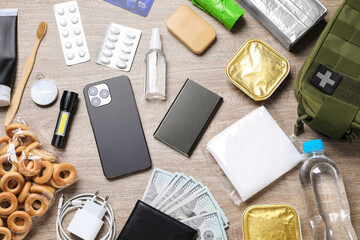Survival kit. Different emergency supplies on wooden table, flat lay