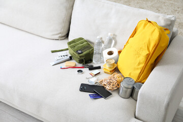 Survival kit. Different emergency supplies on sofa indoors