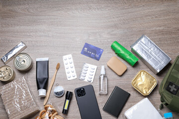 Survival kit. Different emergency supplies on wooden table, flat lay
