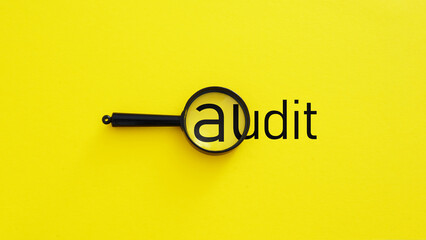 Audit wording with magnifier glass as symbol of quality control assurance and ISO concept