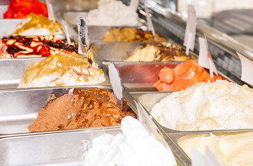 Variety of colorful gelato flavors in stainless steel containers at an ice cream parlor